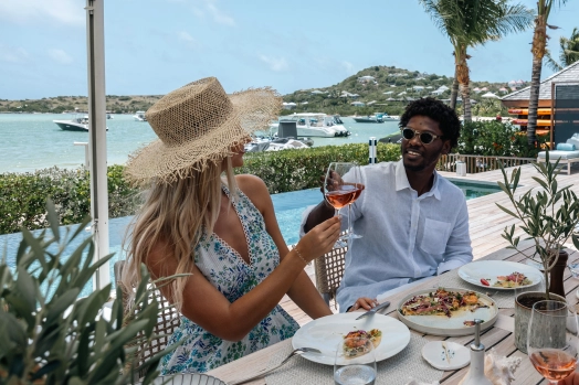 Guests enjoying a meal by the pool at Villa Aqua & Bleu